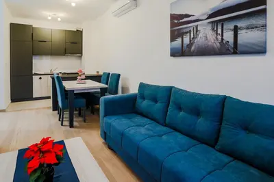 a living room with a blue couch and a table at Montesun Boka Apartments in Budva