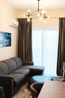 a living room with a couch and a large window at Montesun Boka Apartments in Budva