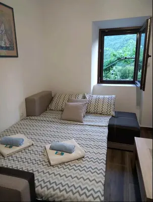 a small room with a bed and a window at Aleksa in Cetinje