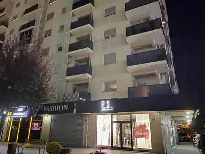 a building with a fashion store in front of it at night at City Apartment in Podgorica