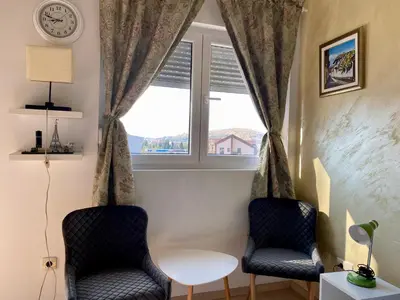 two chairs and a table in front of a window at City Apartment in Podgorica