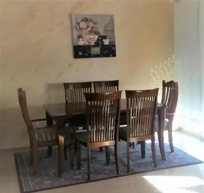 a dining room with a wooden table and chairs at City Apartment in Podgorica