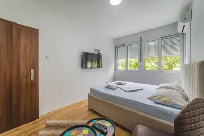 a bedroom with a bed and a tv on the wall at Top-Top in Podgorica
