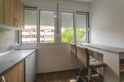 a kitchen with a counter and two windows at Top-Top in Podgorica