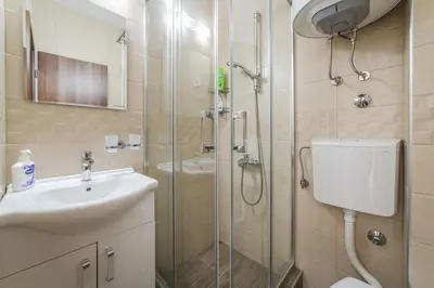 a bathroom with a shower and a sink and a toilet at Top-Top in Podgorica