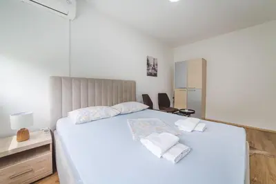 a bedroom with a large white bed with towels on it at Top-Top in Podgorica