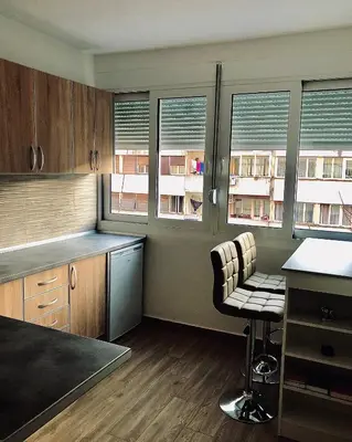 a kitchen with a table and chairs and windows at Top-Top in Podgorica