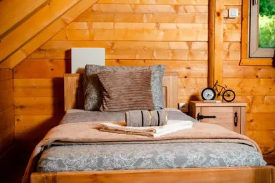 a bedroom with a bed in a wooden cabin at Green Field Apartments in Virpazar