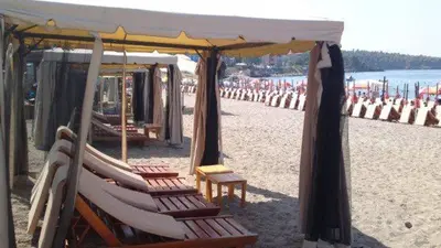 a group of chairs and umbrellas on a beach at Villa Jovanovic Sutomore in Sutomore