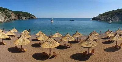 a bunch of umbrellas on a beach with the ocean at Villa Jovanovic Sutomore in Sutomore