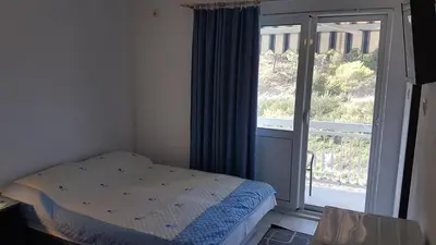 a bedroom with a bed and a large window at Villa Jovanovic Sutomore in Sutomore