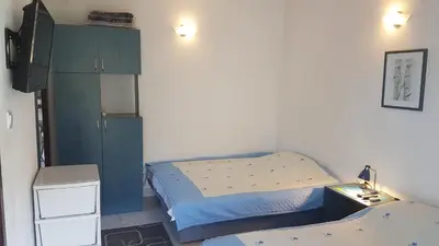 a small bedroom with two beds and a tv at Villa Jovanovic Sutomore in Sutomore