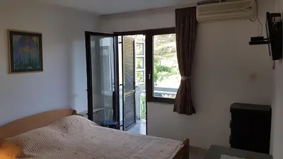 a bedroom with a bed and a sliding glass door at Villa Jovanovic Sutomore in Sutomore