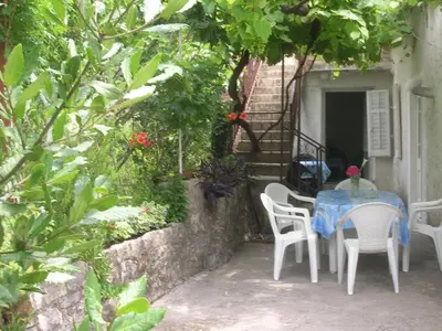 a table with white chairs and a blue table cloth at Vicky Apartments in Kotor
