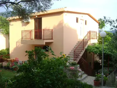a house with a staircase in front of it at Apartments Kovačević in Petrovac na Moru