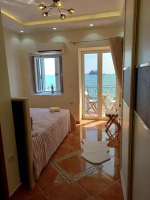 a bedroom with a bed and a view of the ocean at Beach House in Petrovac na Moru