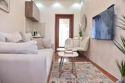 a living room with a white couch and a table at Beach House in Petrovac na Moru