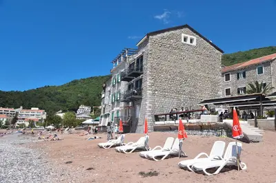 a group of lounge chairs on a beach at Beach House in Petrovac na Moru