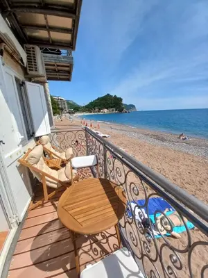 a balcony with a table and chairs on the beach at Beach House in Petrovac na Moru