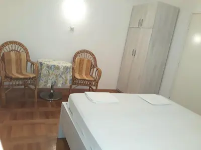 a room with two chairs and a bed and a table at Apartments Đurašević Ivo in Sveti Stefan