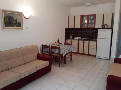 a living room with a couch and a table and a kitchen at Apartments Đurašević Ivo in Sveti Stefan