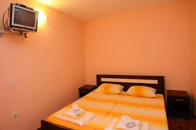 a small bedroom with a bed with towels on it at Vila Apartments Lidija in Petrovac na Moru