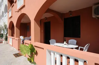a balcony of a building with a table and chairs at Vila Apartments Lidija in Petrovac na Moru