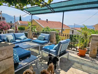 a patio with a couch and a chair and two dogs at Villa Vi apartmen in a villa with a swimming pool in Bar