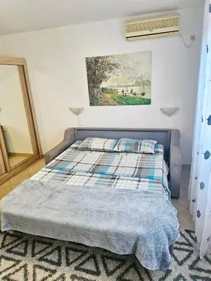 a bed in a bedroom with a painting on the wall at Villa Vi apartmen in a villa with a swimming pool in Bar