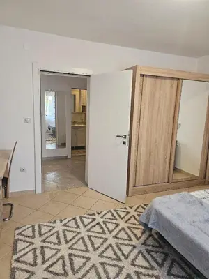 a room with a bed and a door and a table at Villa Vi apartmen in a villa with a swimming pool in Bar