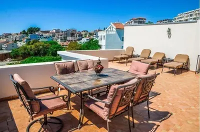a patio with a table and chairs on a roof at Vera Apartments in Ulcinj