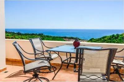 a table and chairs on a balcony with the ocean at Vera Apartments in Ulcinj