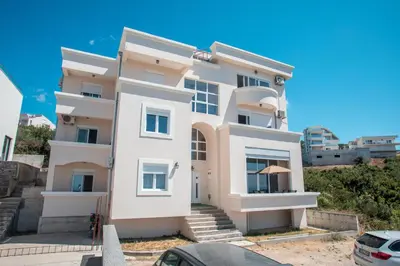 a white building with stairs in front of it at Vera Apartments in Ulcinj