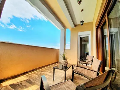a balcony with a table and chairs and a large window at Vila Uma in Bar