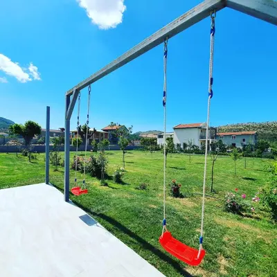 a swing yard with red swings in a field at Vila Uma in Bar