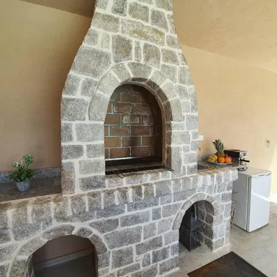 a stone fireplace in a living room with a stone at Vila Uma in Bar