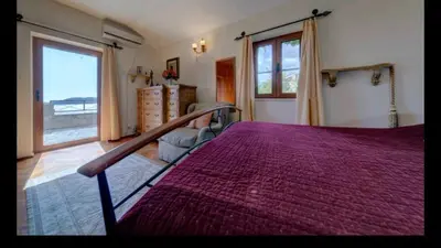 a bedroom with a bed with a purple bedspread at Holiday Homes Sunset Hill in Sveti Stefan