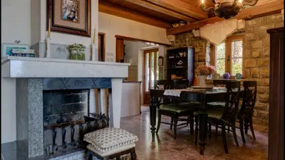 a living room with a fireplace and a table and chairs at Holiday Homes Sunset Hill in Sveti Stefan