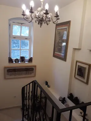 a dining room with a chandelier and a window at Holiday Homes Sunset Hill in Sveti Stefan