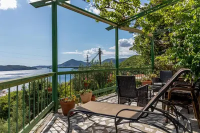 a balcony with chairs and a view of the water at Holiday Homes Sunset Hill in Sveti Stefan