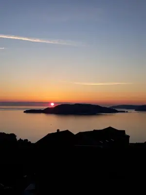 a sunset over a large body of water at Holiday Homes Sunset Hill in Sveti Stefan