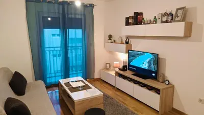 a living room with a flat screen tv and a couch at Guest House Mikeli (BESPL. DORUCAK)-(FREE BREAKFAST) in Podgorica