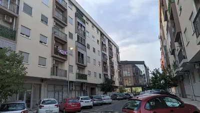a city street with cars parked in front of buildings at Guest House Mikeli (BESPL. DORUCAK)-(FREE BREAKFAST) in Podgorica