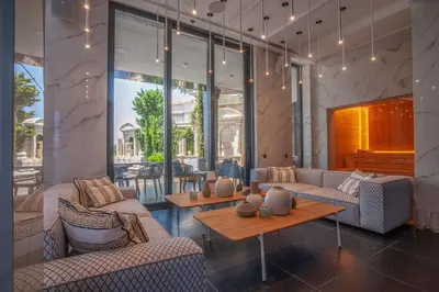 a lobby with couches and tables and windows at Villa Geba Boutique Hotel in Sveti Stefan