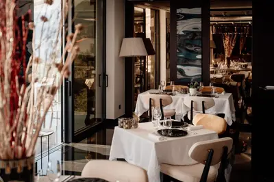 a restaurant with white tables and chairs and a window at Villa Geba Boutique Hotel in Sveti Stefan
