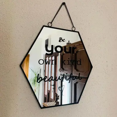 a sign that reads be your own beautiful hanging on a wall at Gara 5 in Kotor
