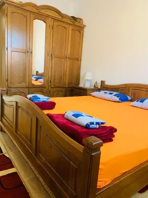 a bedroom with a large wooden bed with blue pillows at Gara 5 in Kotor