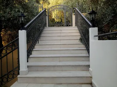 a set of stairs with a metal gate at Oaza Guest House in Sveti Stefan