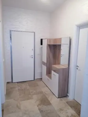 a room with a white refrigerator and a door at Apartman Sadutas in Rafailovici