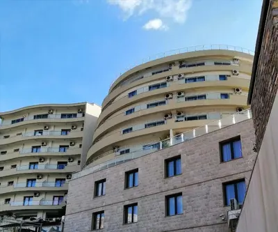 a large apartment building with a round at Apartman Sadutas in Rafailovici